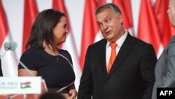 (FILES) Reelected chairman of the governing FIDESZ party, Hungarian Prime Minister Viktor Orban, reacts on the podium beside then elected party deputy-chairman, Hungarian Minister of State for Family and Youth Affairs Katalin Novak (L), during the party c